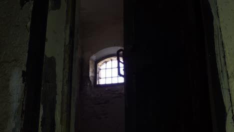 prison's guard open the door of dungeon appearing a window with iron bars