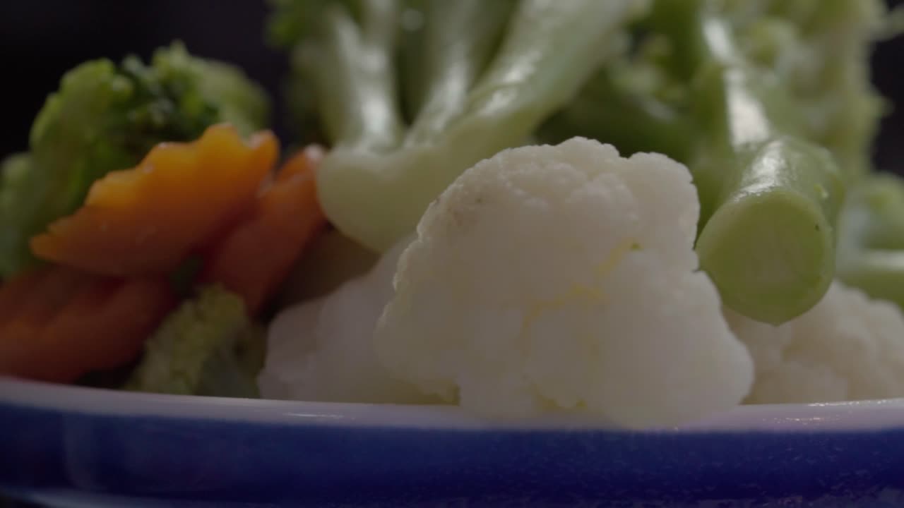 Close-up of Steamed Broccoli and Cauliflower Florets on Blue Plate