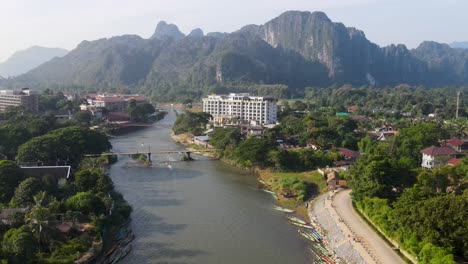 Vista-Aérea-Del-Amanecer-Sobre-El-Río-Nam-Song-Con-El-Hotel-Al-Fondo-En-Vang-Vieng