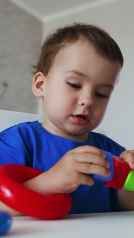 baby boy learning colors and shapes playing with toys. toddler studying through the game. low angle view. vertical video
