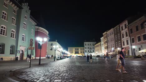 Nighttime overview of Mały Rynek, a small market square in Krakow, lit up with city lights