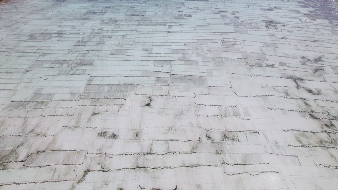 Expansive seaweed cultivation fields spread across shallow lagoon Indonesia, panoramic aerial texture