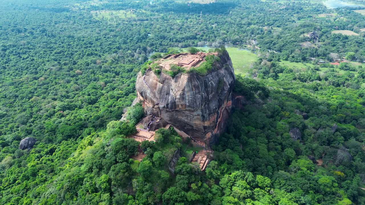 Paesaggio aereo con drone dell'antica fortezza-palazzo rupestre di Sigiriya nella foresta di Dambulla, persone che salgono la scalinata. Viaggi, vacanze e turismo in Sri Lanka, Asia.