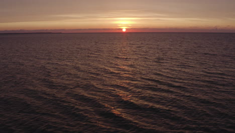 4k-Aerial-shot-of-small-water-waves-in-the-ocean-on-a-beautiful-evening-with-sunset