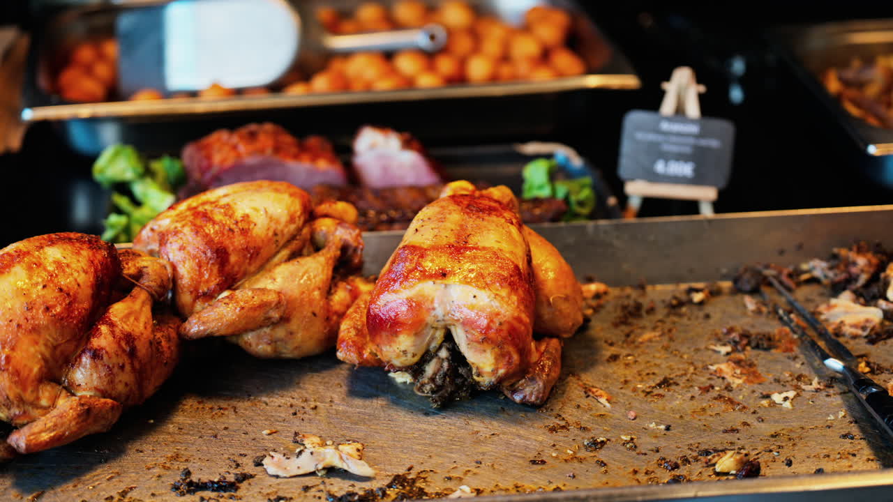Close up of multiple grilled chickens at a food stand