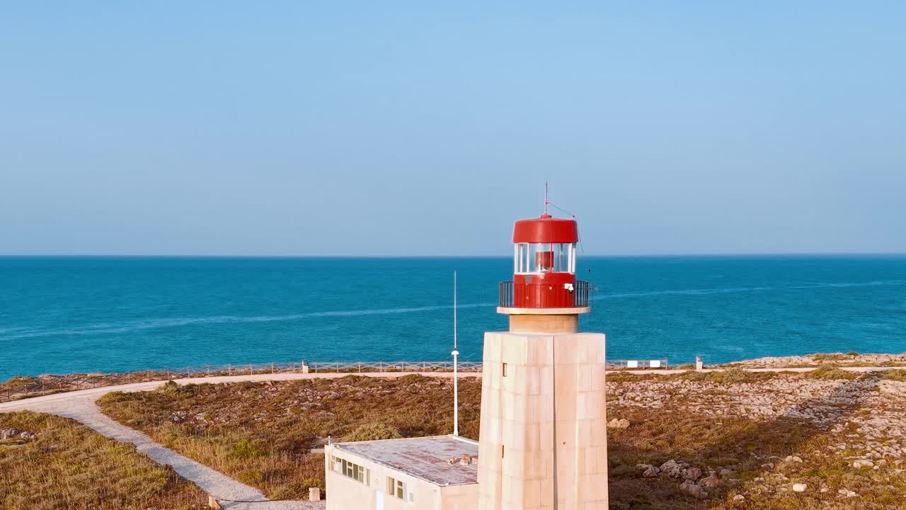 Il faro si erge sulla costa rocciosa vicino all'oceano in Portogallo durante il giorno