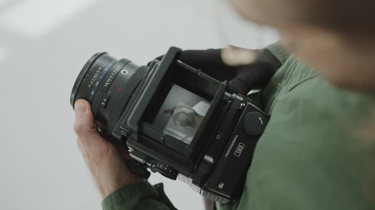 Fotografo che controlla le foto di una modella attraverso il mirino della fotocamera