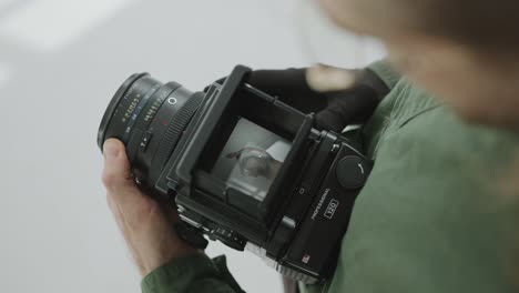 photographer checking photos of model through camera viewfinder