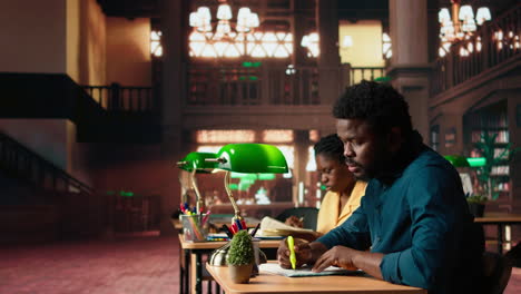 alumno afroamericano subrayando palabras y frases clave en la biblioteca