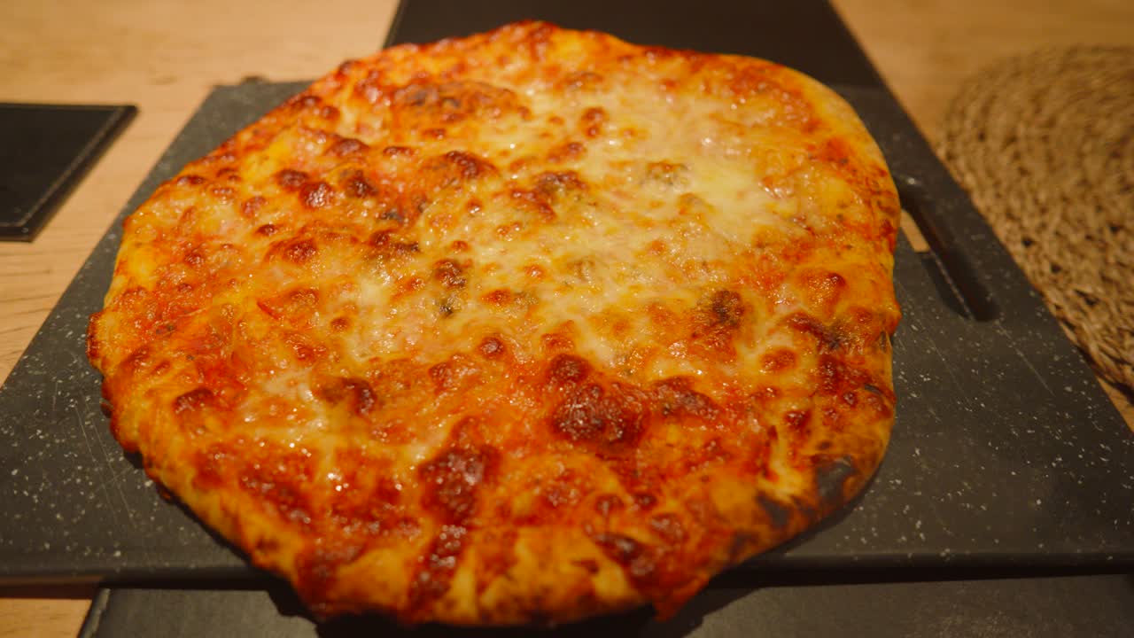 Wide View of Rustic Cheese and Tomato Margherita Resting After Cooking on Serving Board. Italian Food Cuisine with Crsipy Crust.