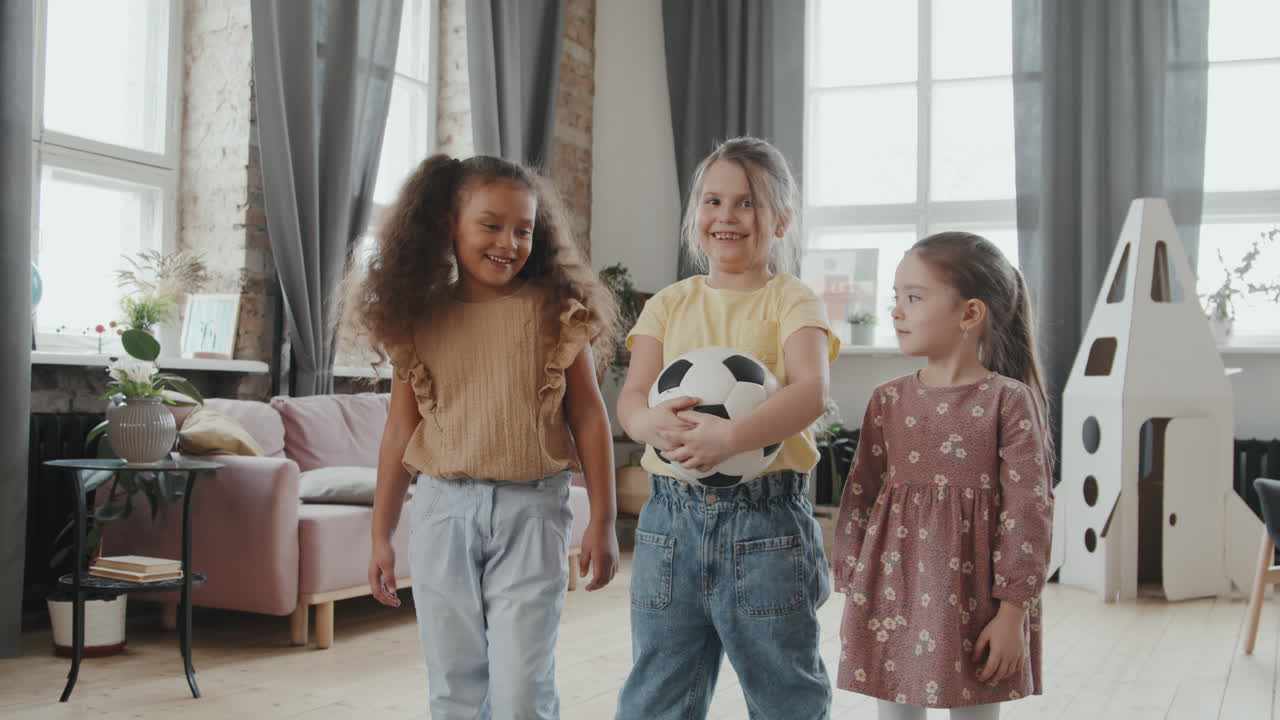 Portrait of Happy Little Girls with Soccer Ball