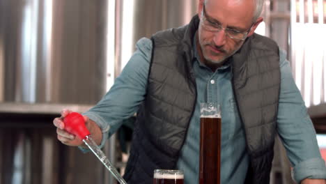 focused brewery worker using pipette