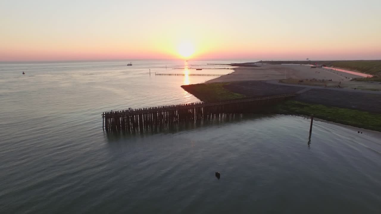 Vista aerea: Il molo, la spiaggia e il faro al tramonto vicino al villaggio di Westkapelle, Paesi Bassi