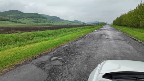 Weißes-Auto-Auf-Einer-Grünen-Landstraße