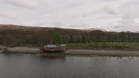 Aerial-dolly-towards-the-famous-Corpach-Shipwreck-with-tourists-exploring