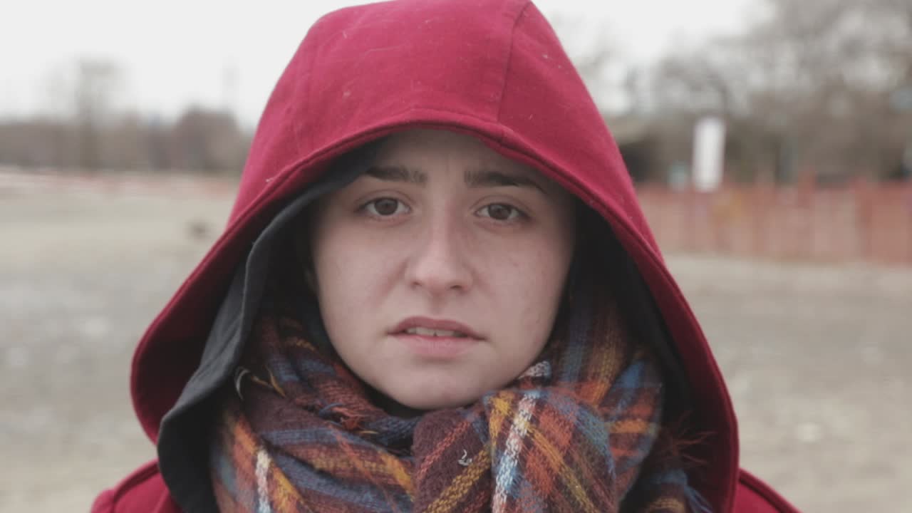 창백하고 슬퍼 보이는 어두운 빨간색 후드를 쓴 여자 - 클로즈업 샷