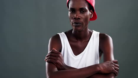 androgynous man posing with red cap