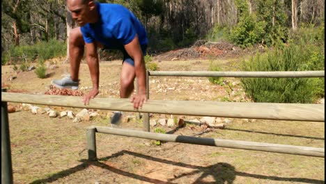hombre en forma saltando sobre los obstáculos durante una carrera de obstáculos