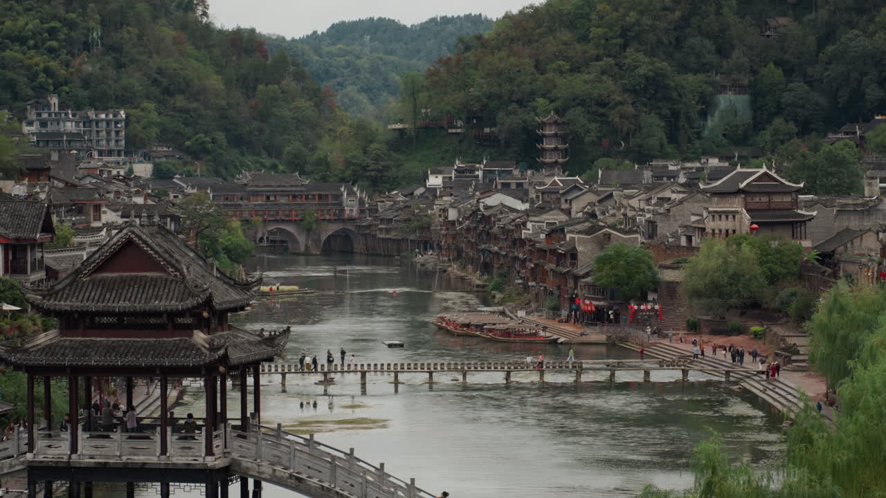 Historic riverside town with wooden pavilion, winding stone bridge and ...