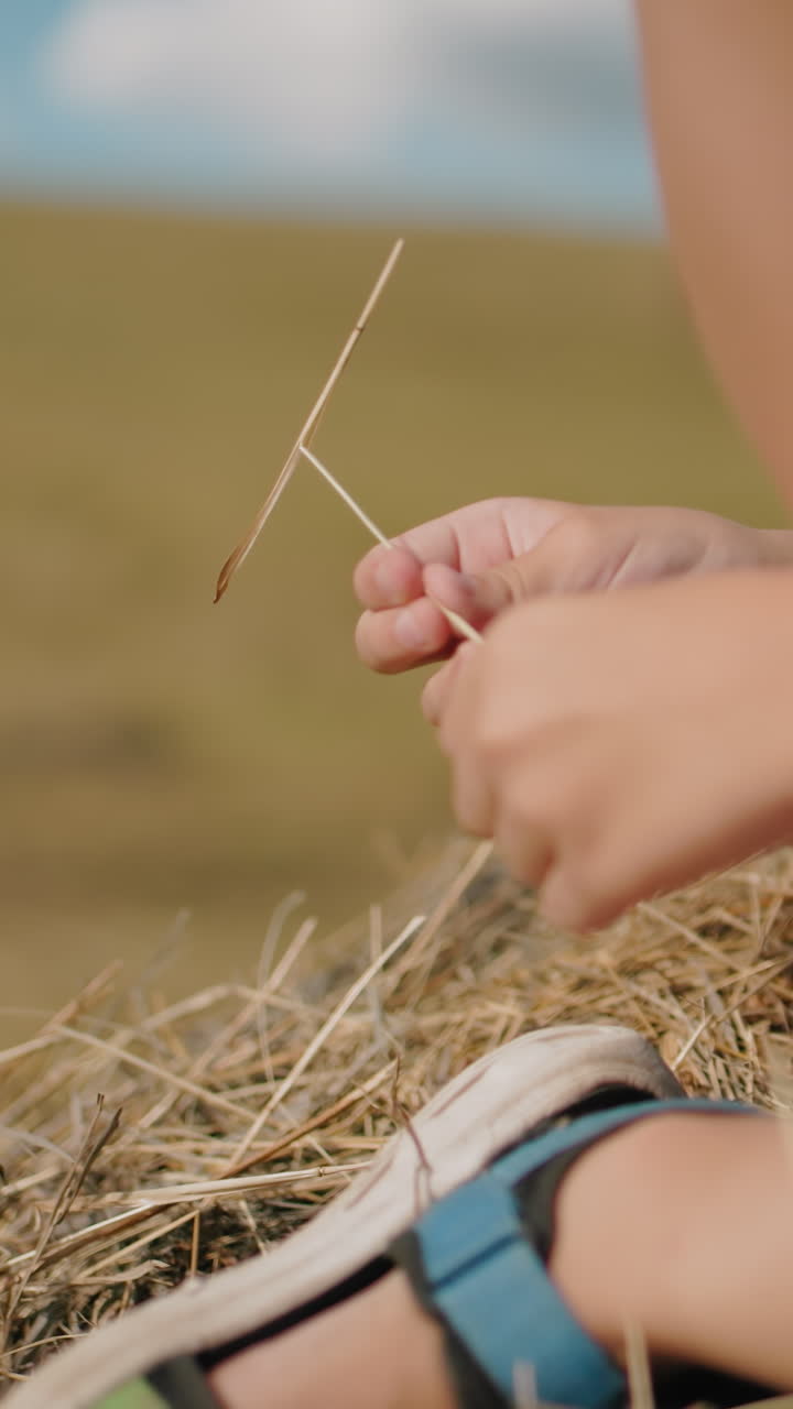 시골의 에 발을 고 있는 어린아이의 클로즈업, 캐주얼 샌달을 입고, 어린아이가 작은 잔디를 들고, 밝은 파란 하늘 아래 평화롭고 따뜻한 여름 날을 즐기고 있다.
