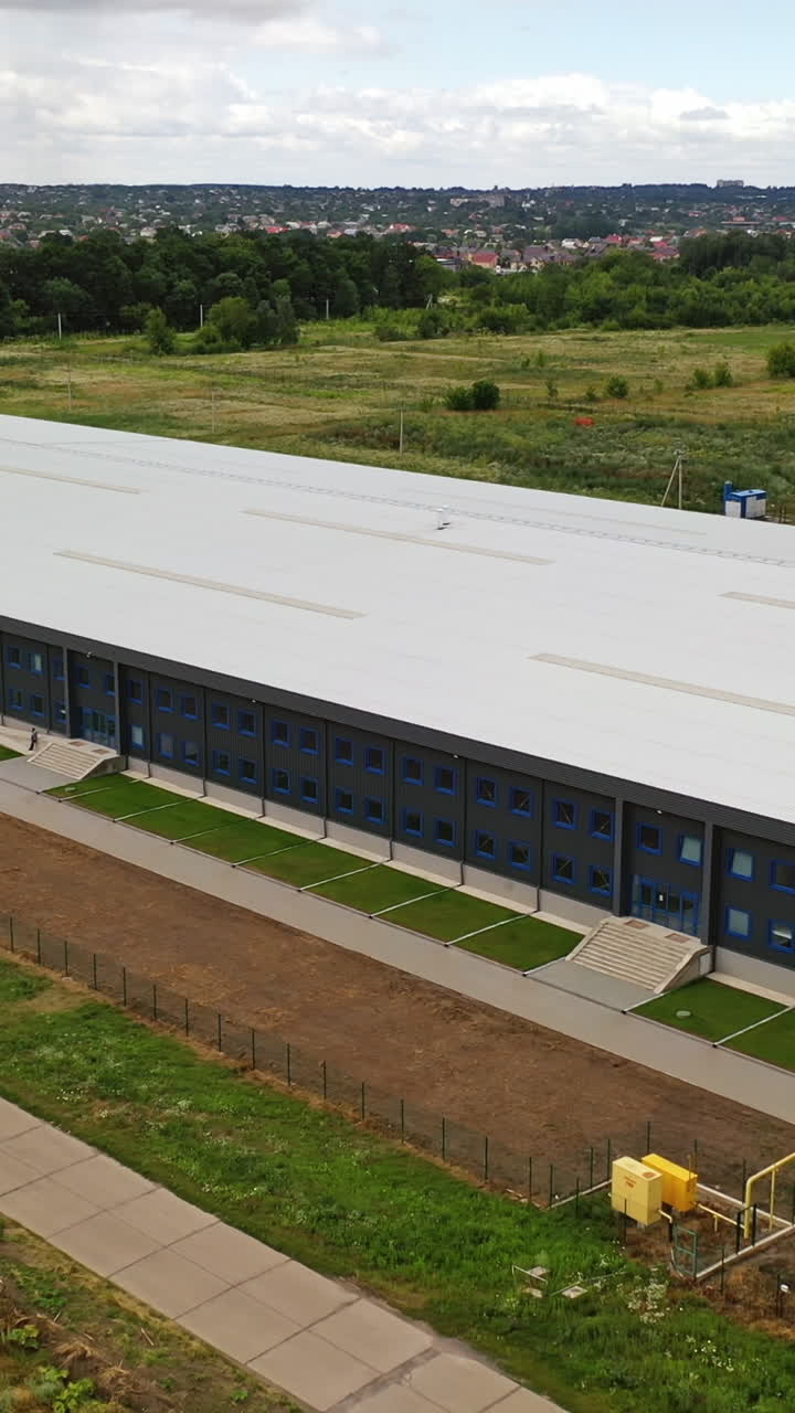 Contemporary industrial factory. Exterior of a large modern production plant in the countryside. Modern production company outdoors. Aerial view. Vertical video