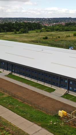 contemporary industrial factory. exterior of a large modern production plant in the countryside. modern production company outdoors. aerial view. vertical video
