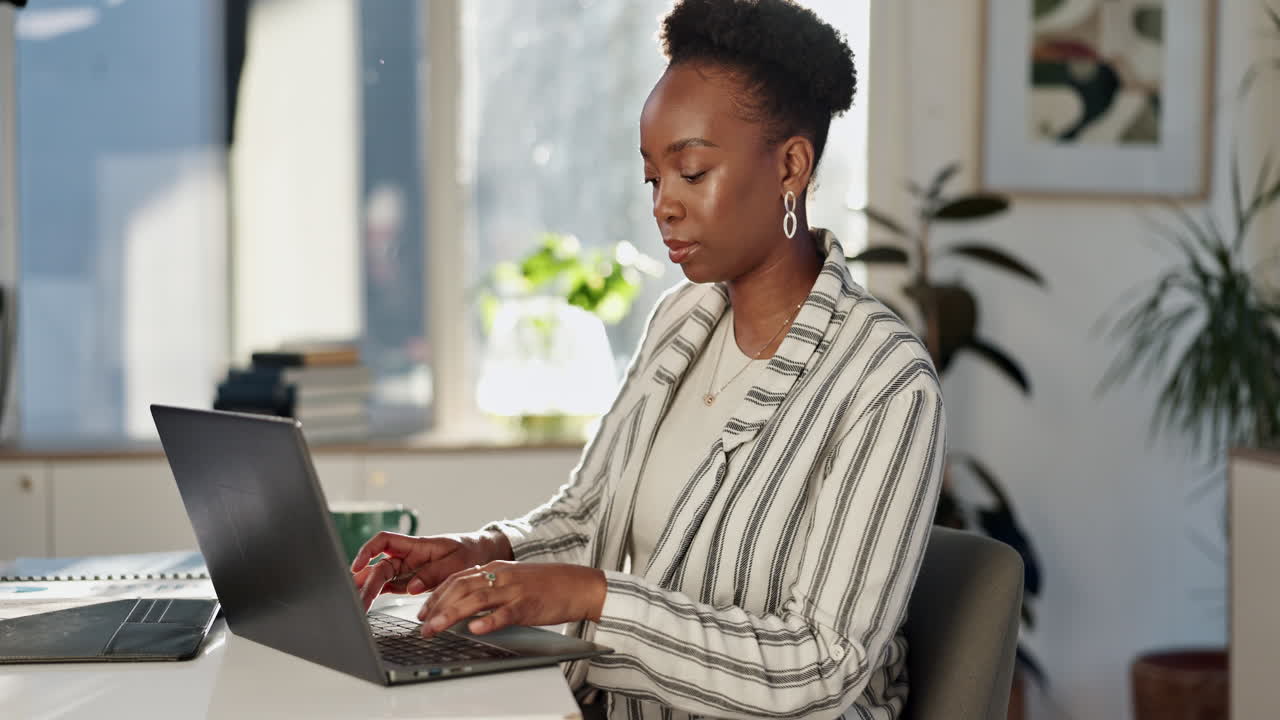 A woman working on her laptop in a bright office