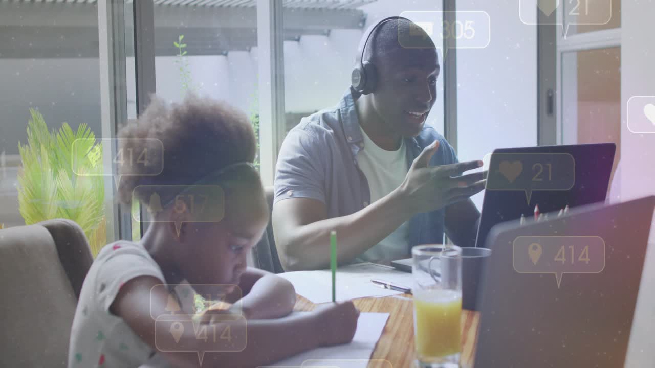 Dad on work call gesturing, causing animated social icons over laptop while girl writing homework