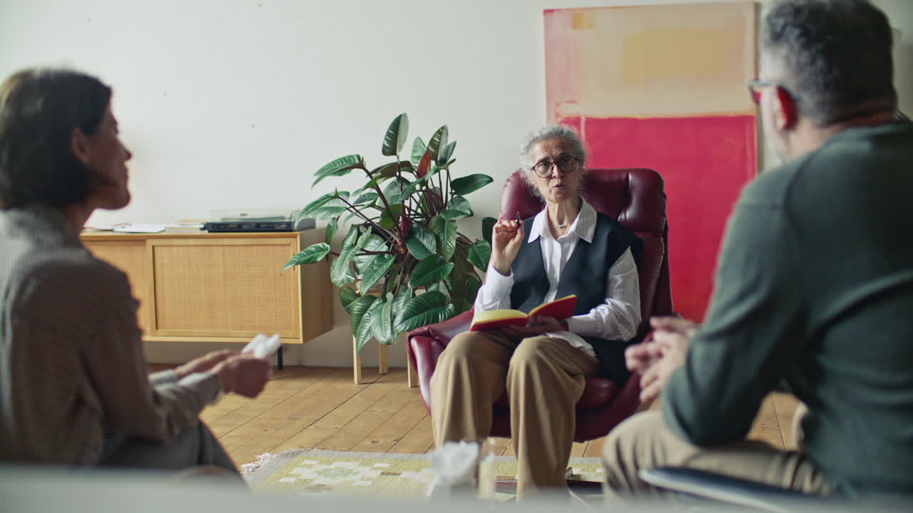 Senior Female Psychologist Leading Therapy Session with Couple