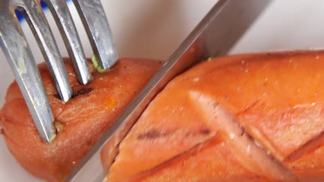 grilled sausage on plate with fork and knife