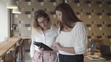 cheerful colleagues with tablet discussing project