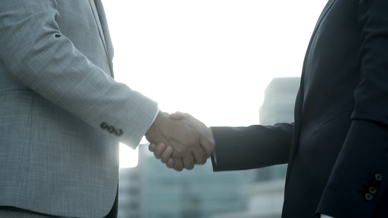 toma en cámara lenta de colegas dándose la mano al aire libre