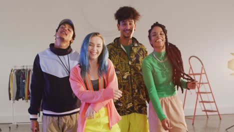 portrait of happy diverse male and female dancers posing in dance studio, slow motion