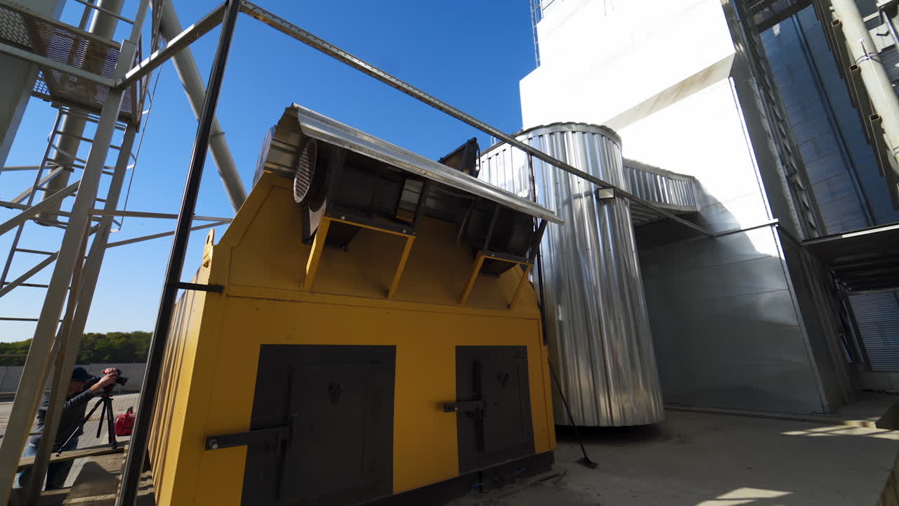 Industrial equipment on agricultural plant. Exterior of modern factory for grain processing. New equipment for agribusiness. Grain elevator.