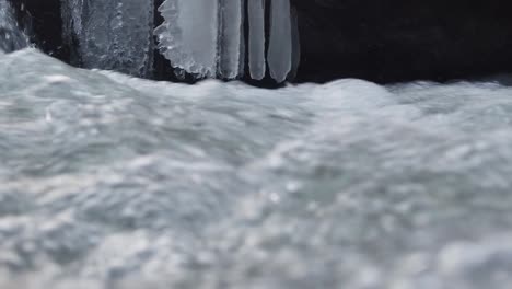 waterfall in the winter season, forming ice and bubble in blue and cold tones