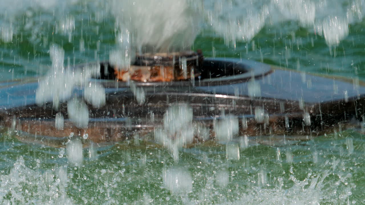 Close up of a fountain nozzle spraying water with powerful jets