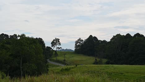 Time-lapse-of-vehicles-moving-up-and-down-the-hilly-road-with-a-beauful-landscape-and-moving-clouds,-Khao-Yai-National-Park,-Thailand