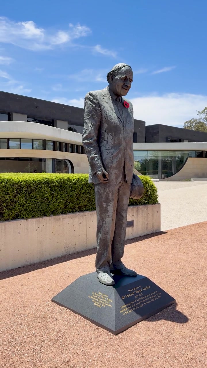Inquadratura ampia statica di una scultura commemorativa in bronzo sotto la luce intensa del giorno a Canberra, Australia