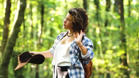 mujer viajando con sombrero en el bosque