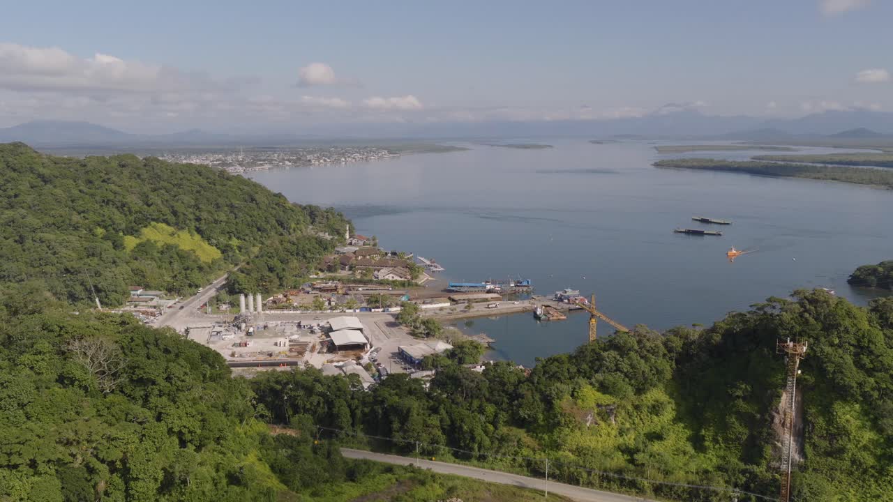 Panorama aerial view of Guaratuba-Caiobá bay with industrial port area between the valley of green hills, South America, Paraná, Brazil