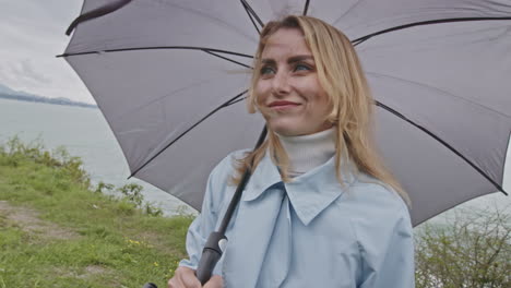 woman with umbrella by the ocean on a rainy day