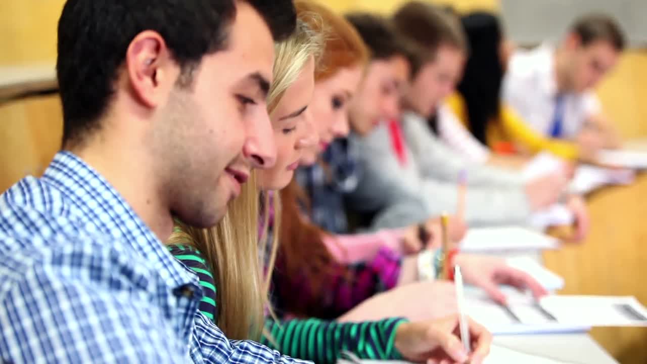 Row of happy students listening in a lecture hall
