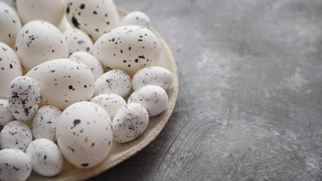 Composition-of-white-traditional-dotted-Easter-eggs-in-white-ceramic-plate