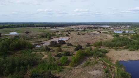 Scenic-aerial-view-of-Plateaux-Hageven,-nature-reserve-landscape-with-forest-and-ponds