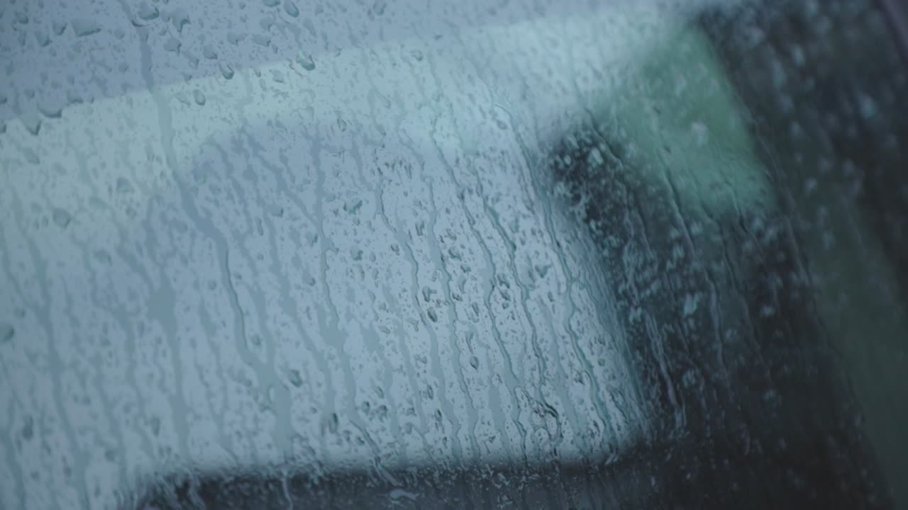 Rain Falling On The Glass Of A Windshield. - close up shot