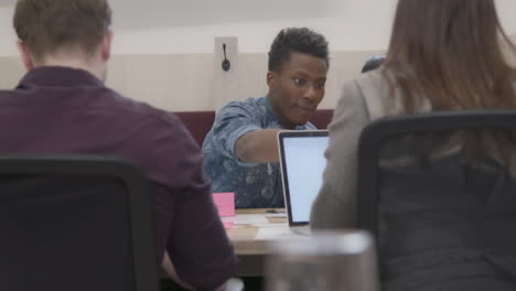 Male And Female Colleagues Working Together In Office