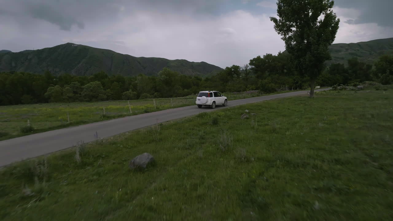 조지아의 일몰에 시골을 흐르는 강으로 가는 길에서 운전하는 하얀 차 위를 날다