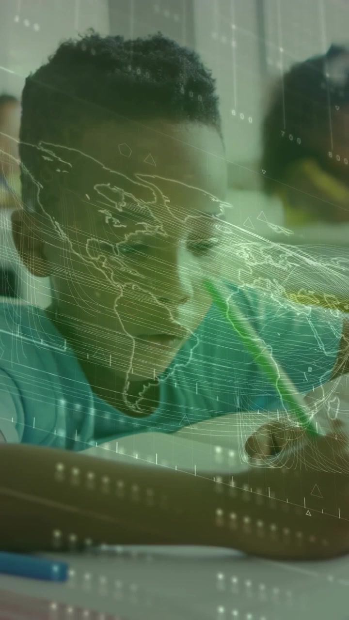 Vertical video: Student boy lowering pencil and beginning writing in class, HUD overlaying desk