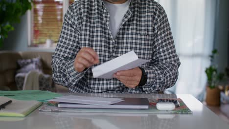 man reading and sorting financial documents at home