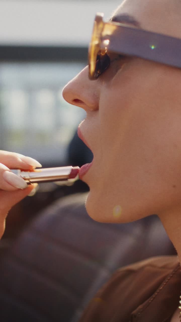 mujer aplicando lápiz labial al aire libre